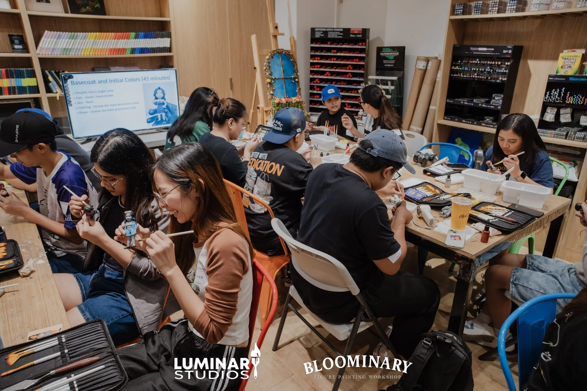 Participants painting figures at a Bloominary workshop table